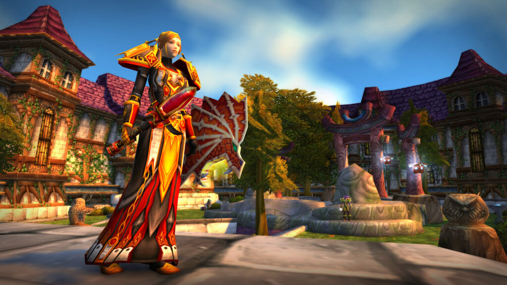 A female Paladin in red and gold armor standing in Stormwind, the Alliance capital in WoW Classic, showcasing a well-equipped character.